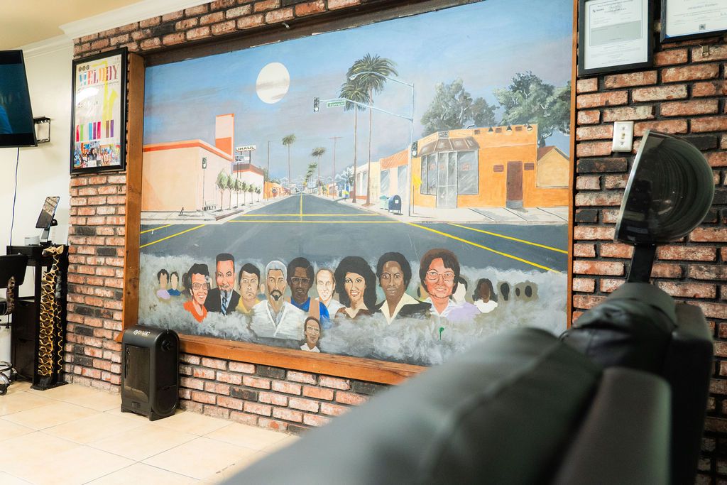 Community mural depicting local residents and a street scene inside Realities Phase II Salon