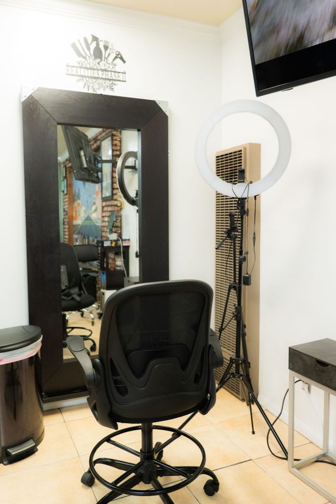 Modern styling station with black framed mirror and LED ring light at Realities Phase II Salon
