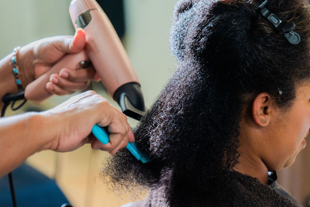 Master Stylist Jacquelyn Baldwin receiving a blow-dry service at Realities Phase II Salon