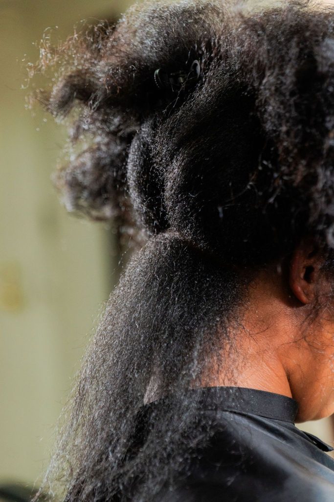 Natural textured hair being prepared for hair augmentation and extension installation